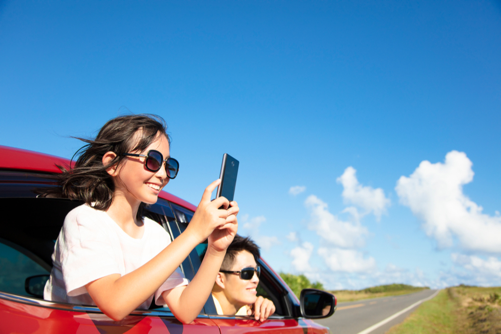 young-girl-taking-picture-from-car