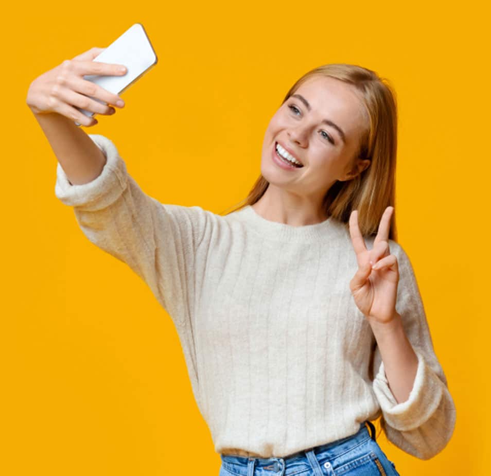 Teen Girl taking selfie with yellow wall